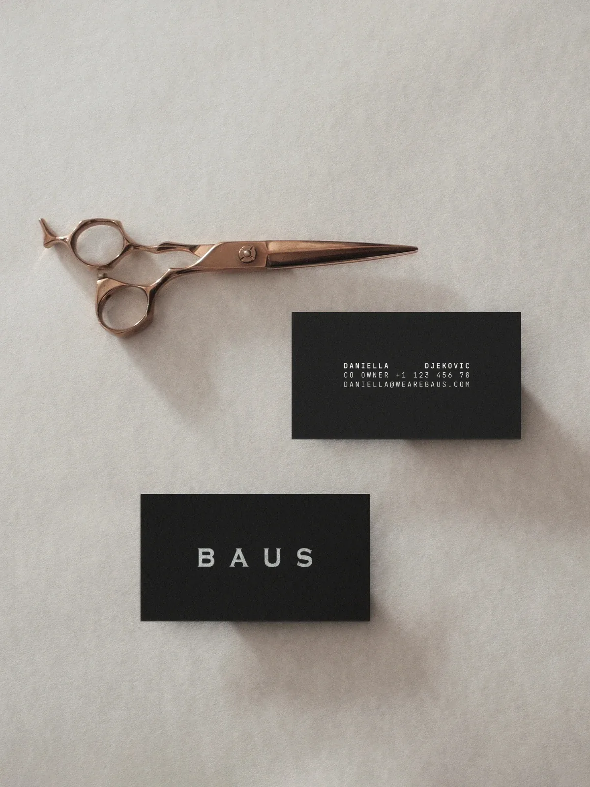 Black Baus business cards with rose-gold barber scissors