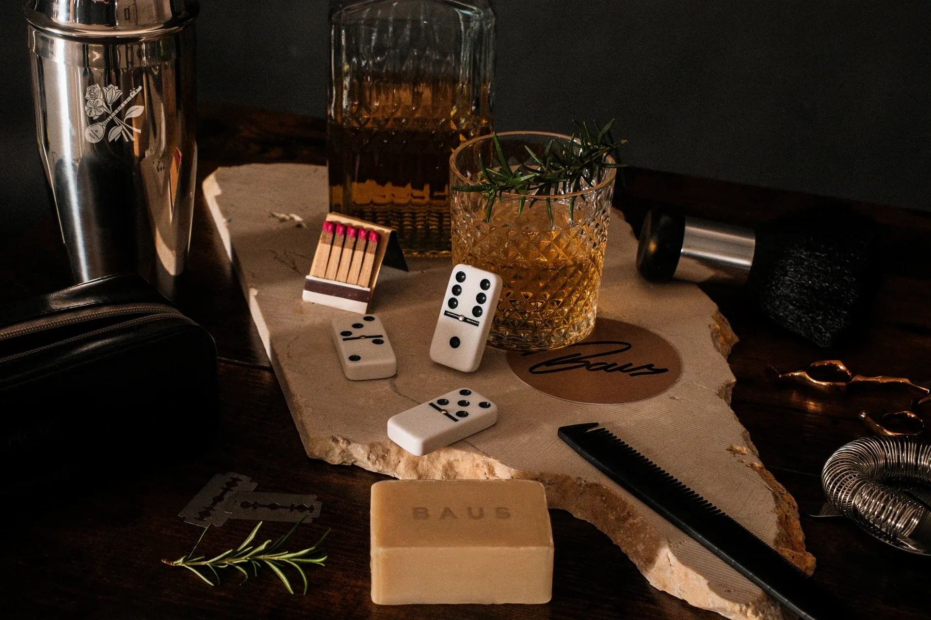 Baus matches, dominoes, soap bar and whiskey glass on marble