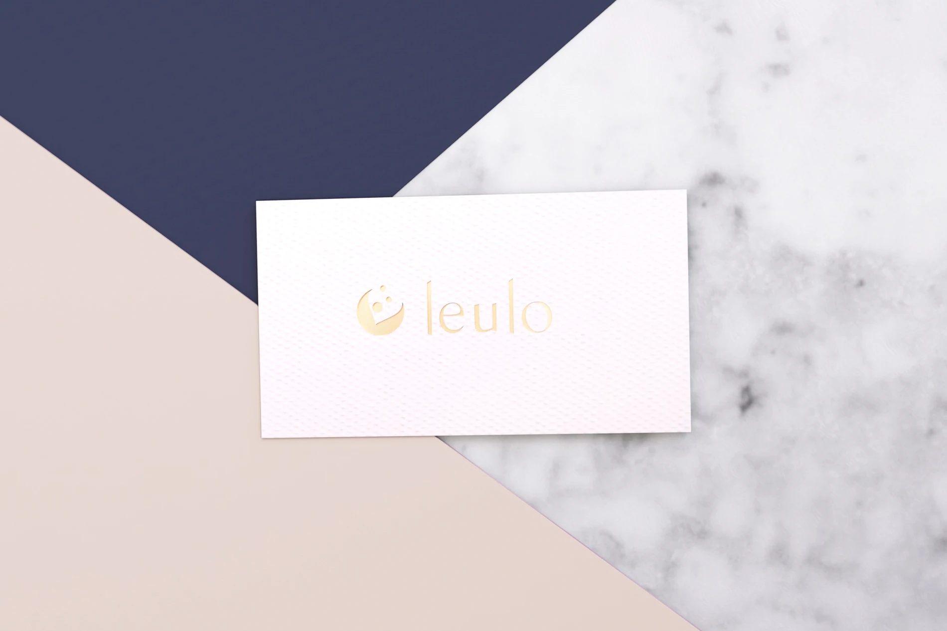 Leulo business card with gold logo on pink, navy and marble